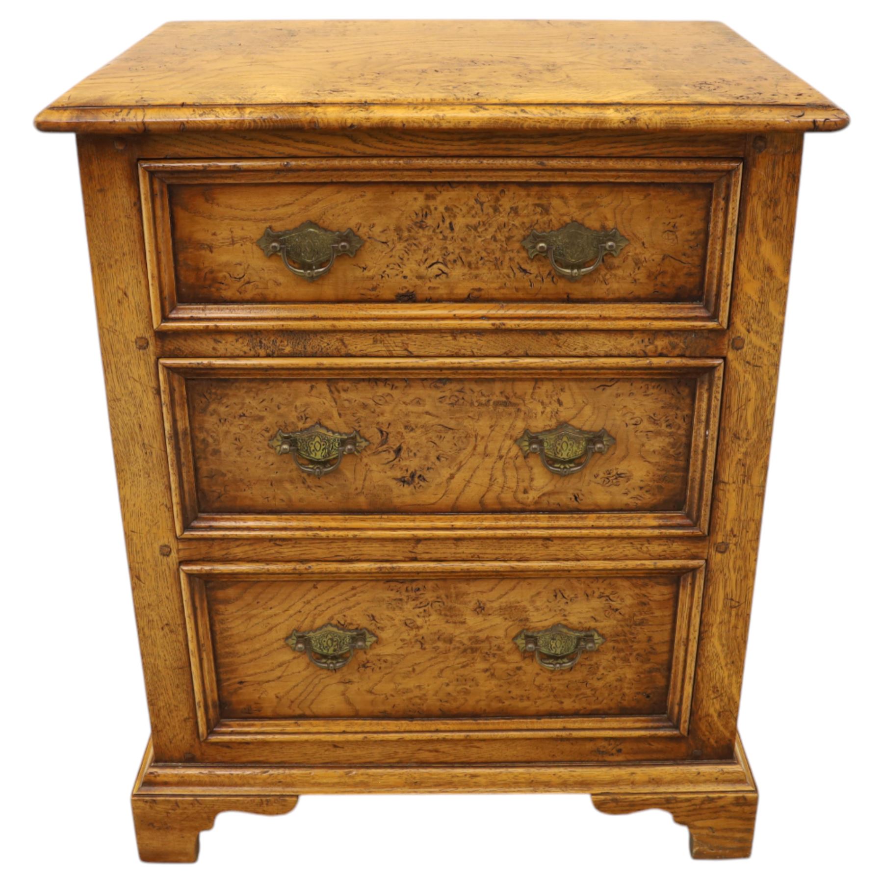 Small 20th century burr oak chest, the figured top over three graduated drawers with moulded fronts and pierced brass handles, on shaped feet