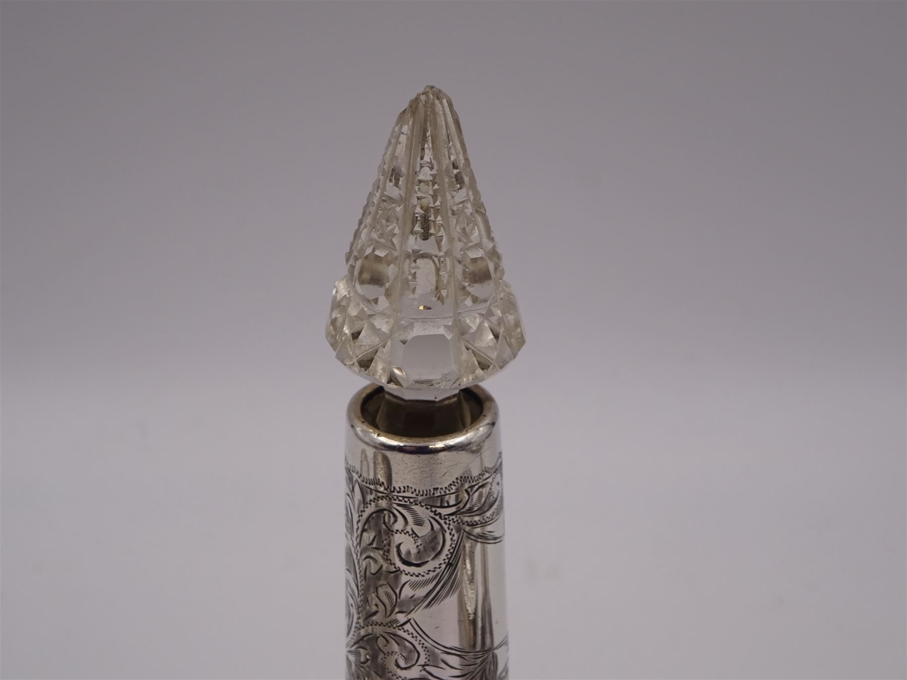 Two silver mounted dressing table jars, one in the form of a heart, both with embossed silver covers and cut glass bodies, hallmarked, together with two smaller examples, one set with mother of pearl, three silver mounted glass scent bottles, including an example with prunus blossom decoration, stamped Sterling, tallest bottle H17cm
