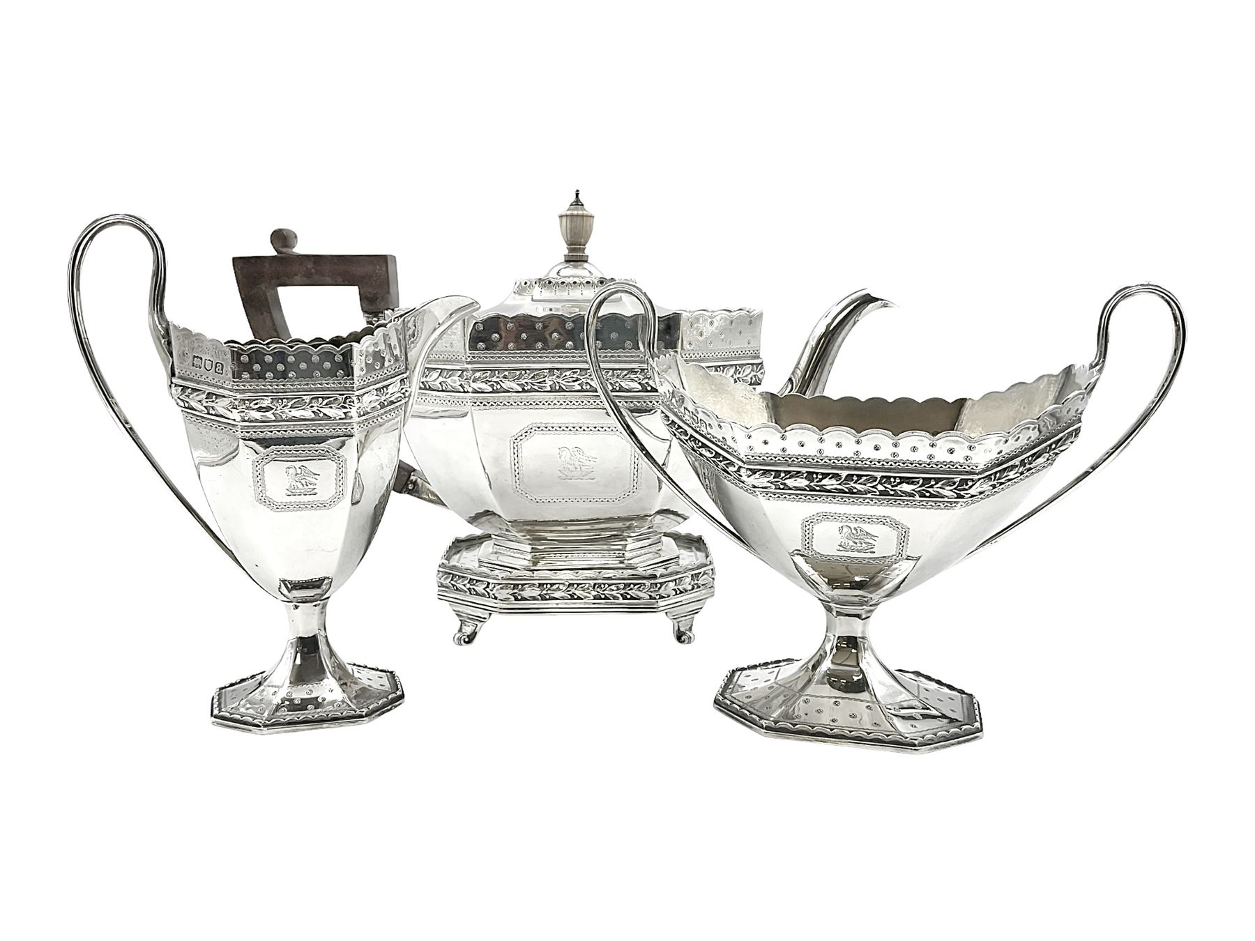 Victorian silver four piece tea service, comprising teapot, teapot stand, twin handled open sucrier and milk jug, each of octagonal form with foliate bud border and engraved decoration including crest to canted panels, and vacant panels, the teapot with ivory finial to the hinged cover and later wooden handle, hallmarked Edward Barnard & Sons Ltd, London1896, teapot including finial H15cm, milk jug including handle H16cm, teapot stand W11.5cm

This item has been registered for sale under Section 10 of the APHA Ivory Act