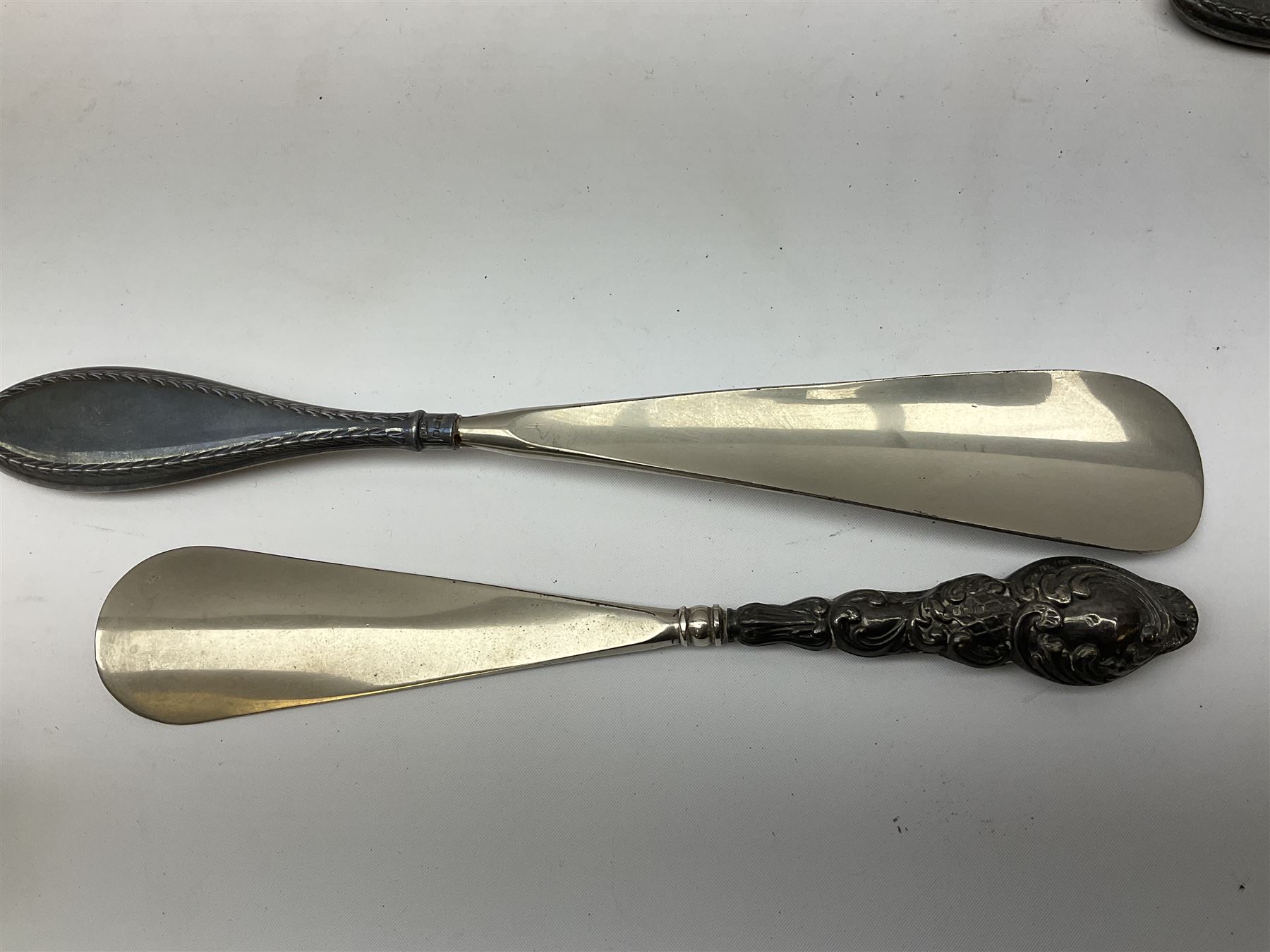 Set of six silver handled butter knives, in case, pair of silver handled fish servers, two silver handled shoe horns, and two silver handled button hooks, all hallmarked or stamped Sterling