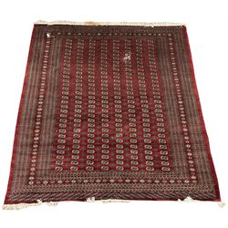 Large Persian Bokhara red ground carpet, the field decorated with eight rows of Gul motifs, wide multi-band borders decorated with repeating geometric motifs