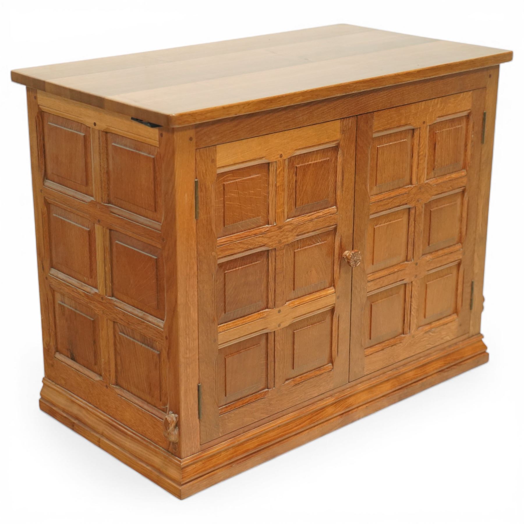  Beaverman - oak media cabinet, rectangular top with interictally carved panels to the side and front doors, twin doors with Yorkshire Rose carved wooden knob, enclosing a staggered shelf arrangement above two drawers, raised on a moulded plinth base, with carved beaver signature, by Colin Almack of Sutton near Thirsk