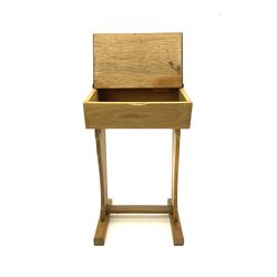 Early 20th century narrow oak school desk, fitted with ink well and hinge lid enclosing book compartment, raised on shaped supports and sledge feet joined by floor stretcher 