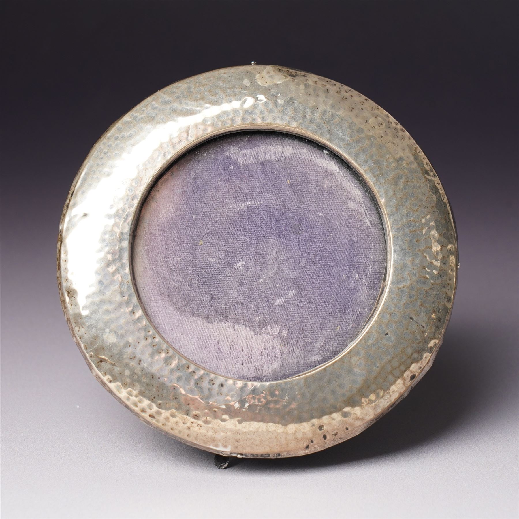 Embossed silver photograph frame London 1985 aperture 12.5cm x 8.5cm, another with scroll top Birmingham 1921 13cm x 9cm and a circular frame Birmingham 1909 6cm