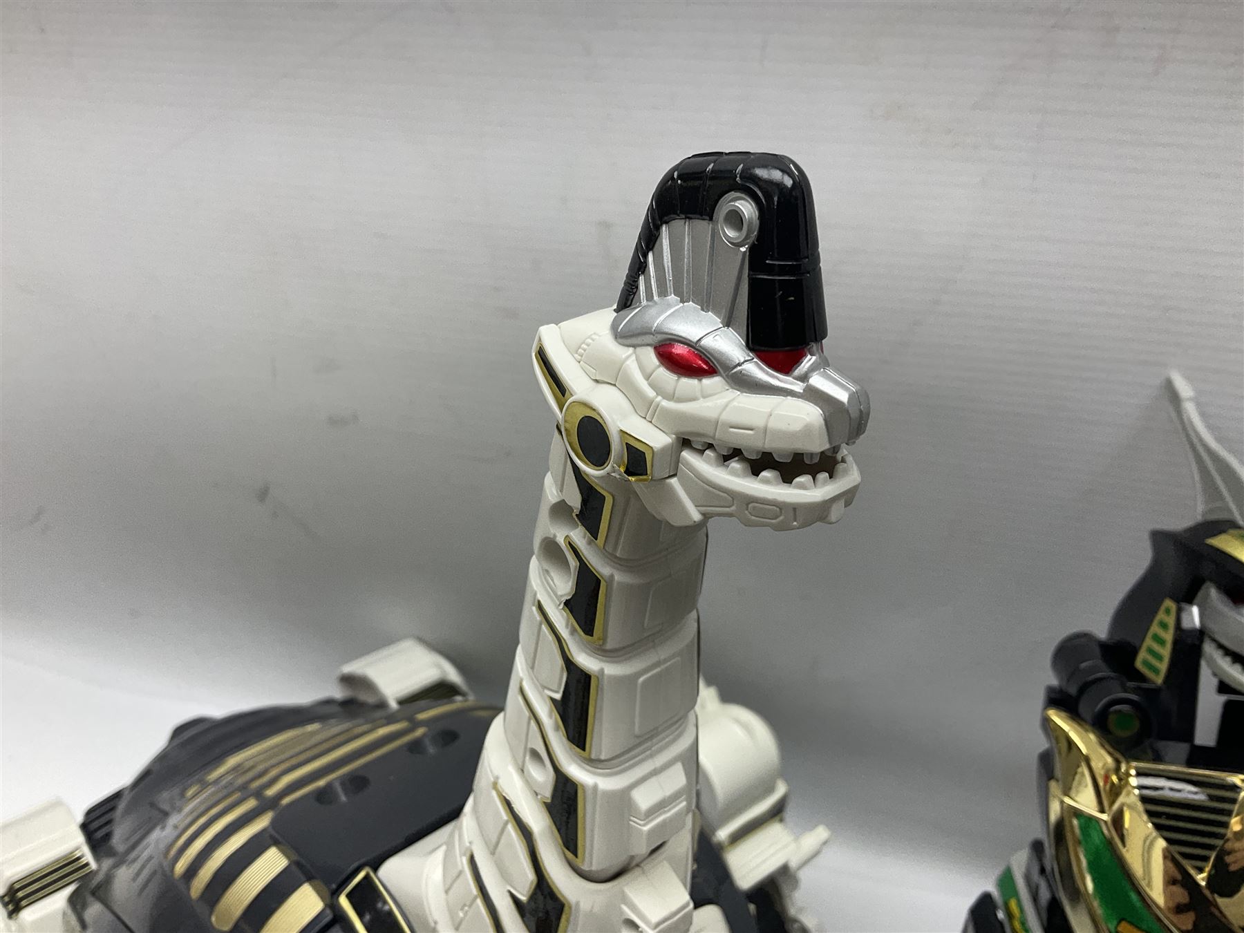 Collection of early 90s Mighty Morphin’ Power Rangers Zords, figures and accessories. Titanus the Carrier Zord, marked Bandai 1991; Green Dragonzord, incomplete; 1994 White Tigerzord with original instruction manual; 1993 Triceratops Dinozord, Mastodon Dinozord and Sabertooth Tiger Dinozord, Pterodactyl Dinozord, missing guns; with 1993 Power Morpher and original Power Coins, with further related figures, accessories and weapons