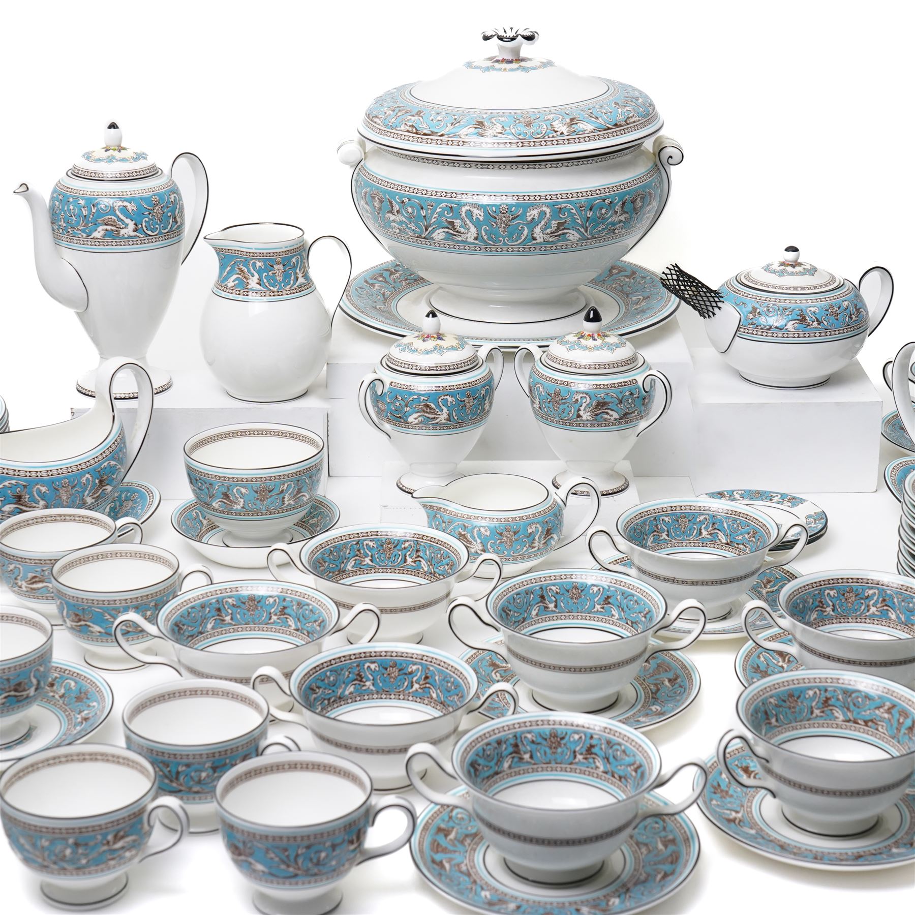 Wedgwood turquoise Florentine part service, comprising large covered tureen and stand, coffee pot, teapot, two covered sucriers, milk jug, two sauce boats and stands, seven soup plates, three bowls, jug, eighteen soup bowls and fifteen stands, two ashtrays, thirteen further saucers, twelve teacups and eleven saucers, and twenty-one further plates of varying sizes