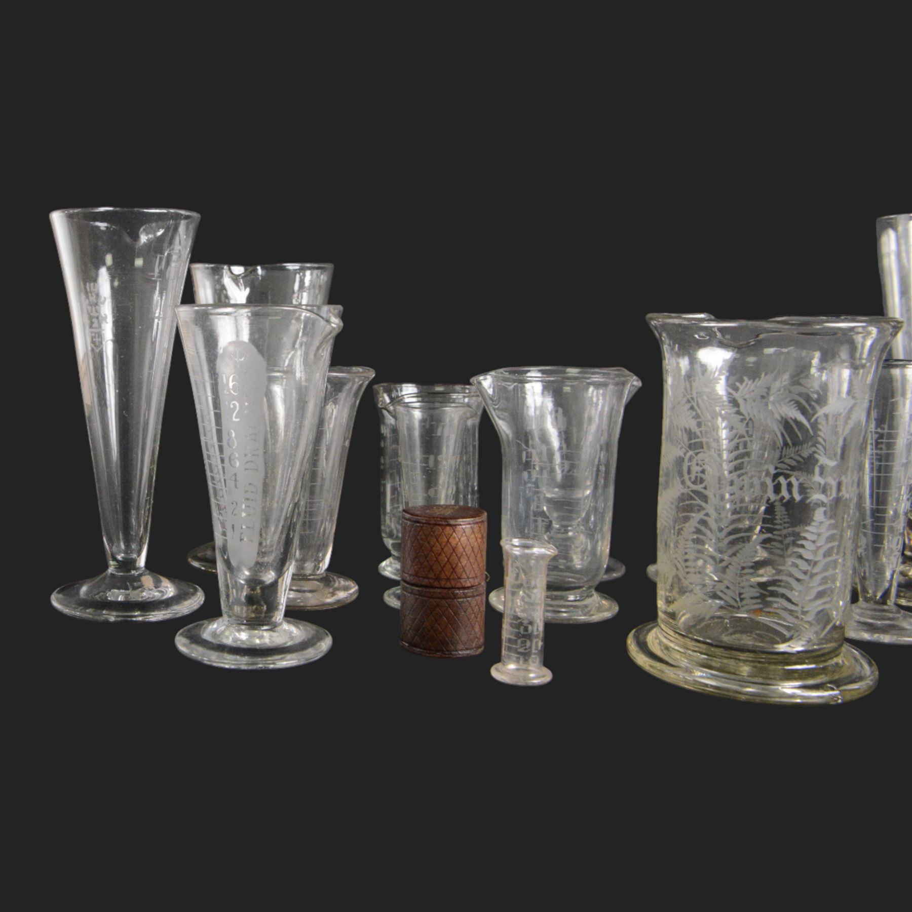 Nineteen apothecary chemists glass measures, of various shapes and age 