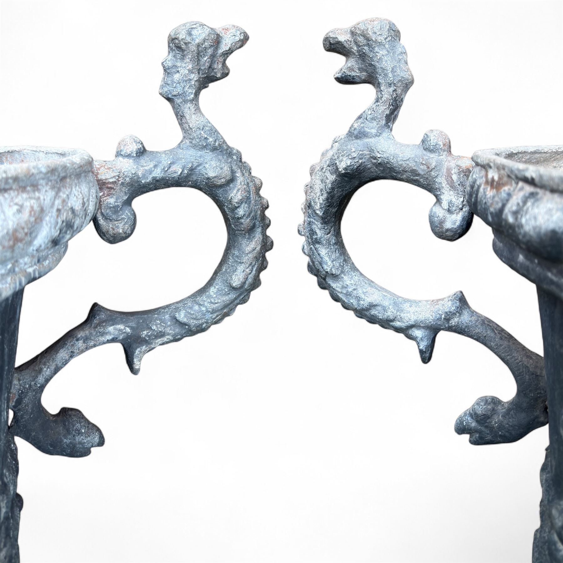 Impressive pair of early highly decorative lead garden urns, griffin handles with ornate decoration depicting cherubs and laurel wreath