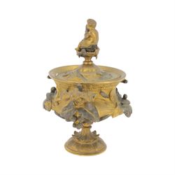 19th century gilt bronze twin handled urn, the removable cover with foliate decoration and finial modelled with a putti and swan, the body decorated in relief with swans and reeds, upon a circular foot, H19cm
