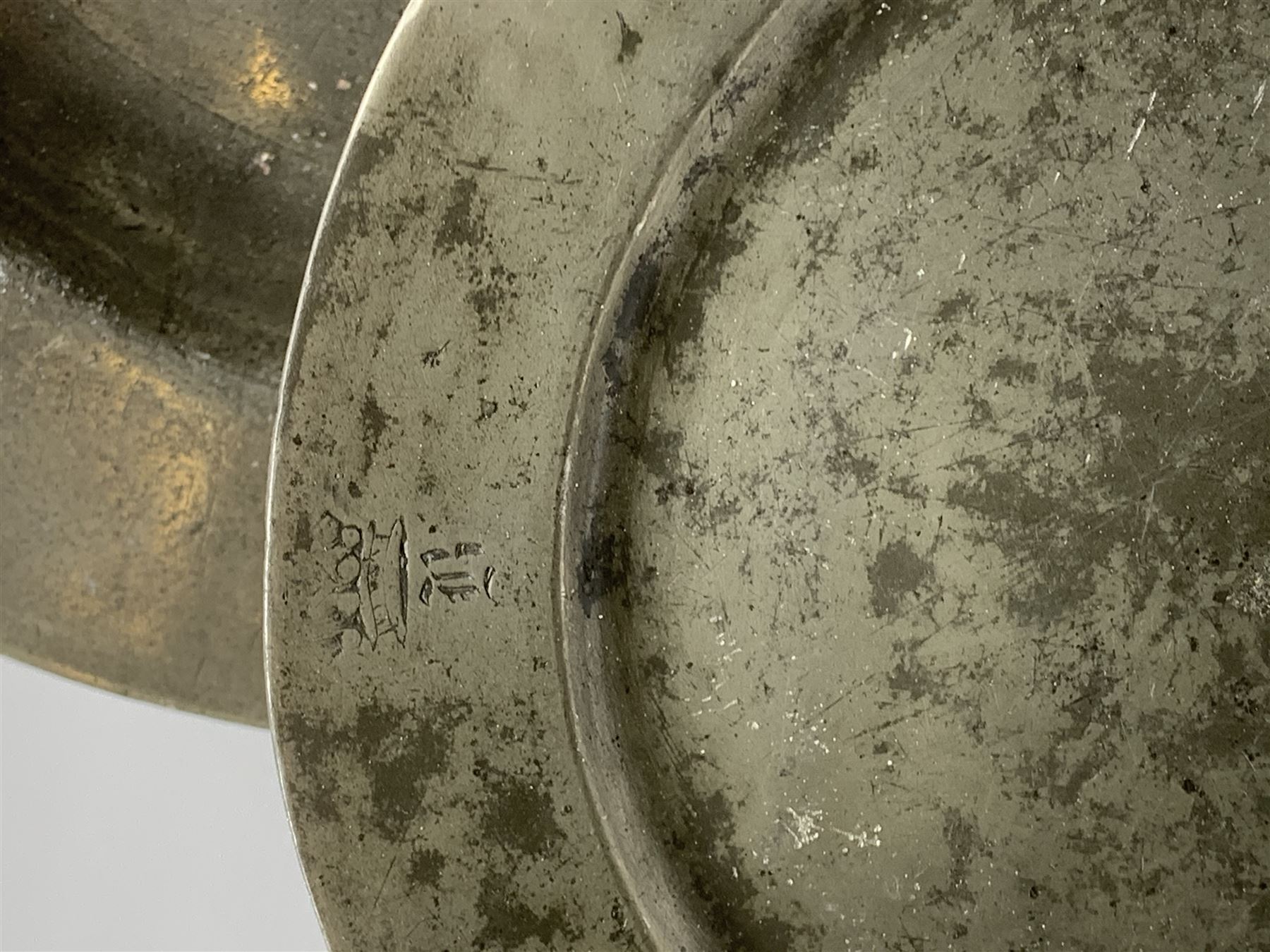 Collection of 18th and 19th century pewter, comprising two chargers, eight large plates, twenty six smaller plates, two bowls, three lidded measures, two jugs, tappit hen, and tankard, the plates with various marks and touch marks, including pseudo 'hallmarks', largest charger 37cm, large plates D30cm, smaller plates D24.5cm, tappit hen H26.5cm