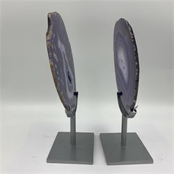 Pair of purple agate slices, polished with rough edges, raised upon silvered metal stands, H26cm