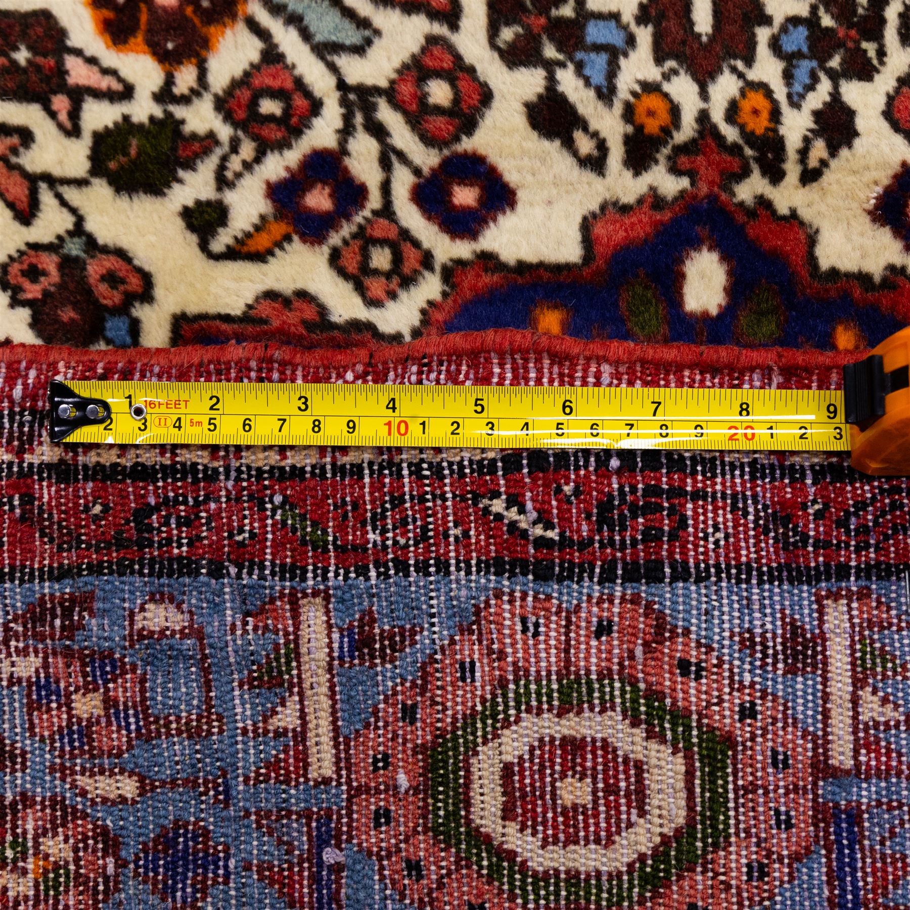 West Persian Hamadan hand-knotted rug, ivory field decorated with a repeating lattice of stylised geometric medallions interspersed with small floral motifs and angular vine ornament enclosed by a sky blue border of stylized rosettes and geometric devices between multiple guard stripes, with cotton fringe ends  