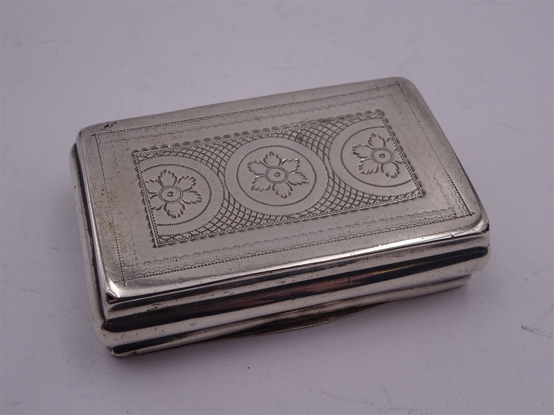 George III silver snuff box, of rectangular form with foliate engraved panel to hinged cover and underside of body, opening to reveal a gilt interior, hallmarked London 1813, makers mark I.B, W6.5cm, approximate 1.86 ozt (57.6 grams)