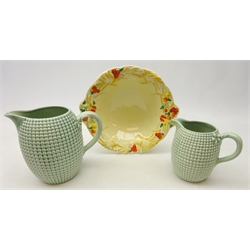  Clarice Cliff Newport Pottery two-handled fruit bowl in the 'Celtic Harvest' pattern W26cm and a graduated pair of Clarice Cliff Newport Pottery green glazed jugs with sweetcorn style moulded bodies (3)  