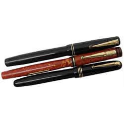 Vintage Swan Mabie Todd lever fill fountain pen in coral red, the nib a/f marked 14K, together with two further vintage Swan Mabie Todd fountain pens, the first example with lever fill, the other leverless, each with black body, one with nib marked 14ct, (3) 