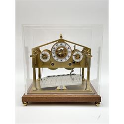 Mid 20th century 'Congreve' rolling ball clock, sloped arch and pierced brass movement, the central Arabic minute chapter ring flanked by hour and seconds dials, twin train driven eight day movement, raised on mahogany plinth with turned brass feet, under acrylic cover
