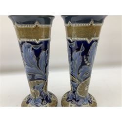 Pair of Doulton Lambeth vases by Emily Stoner, of squat form with flared cylindrical neck, with moulded foliate and bead decoration, H25cm