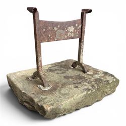 19th century cast iron boot scraper, mounted on a rectangular hewn stone slab base, with scrolled twin upright supports and scraper bar, in weathered finish