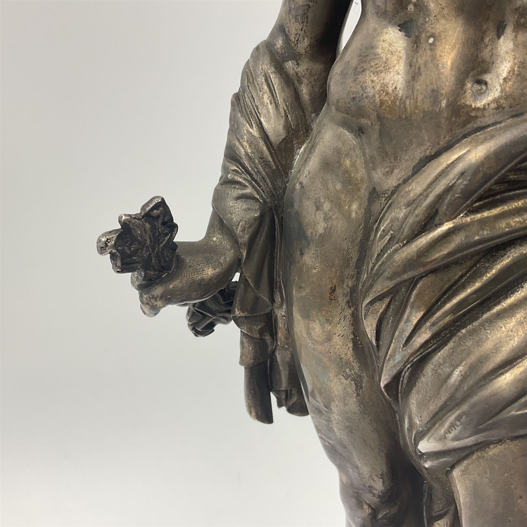 20th century silver plated figure, modelled as a classical male figure, possibly Prometheus, holding flames, one foot resting atop a small dragon, upon a circular spreading base, overall H37.5cm