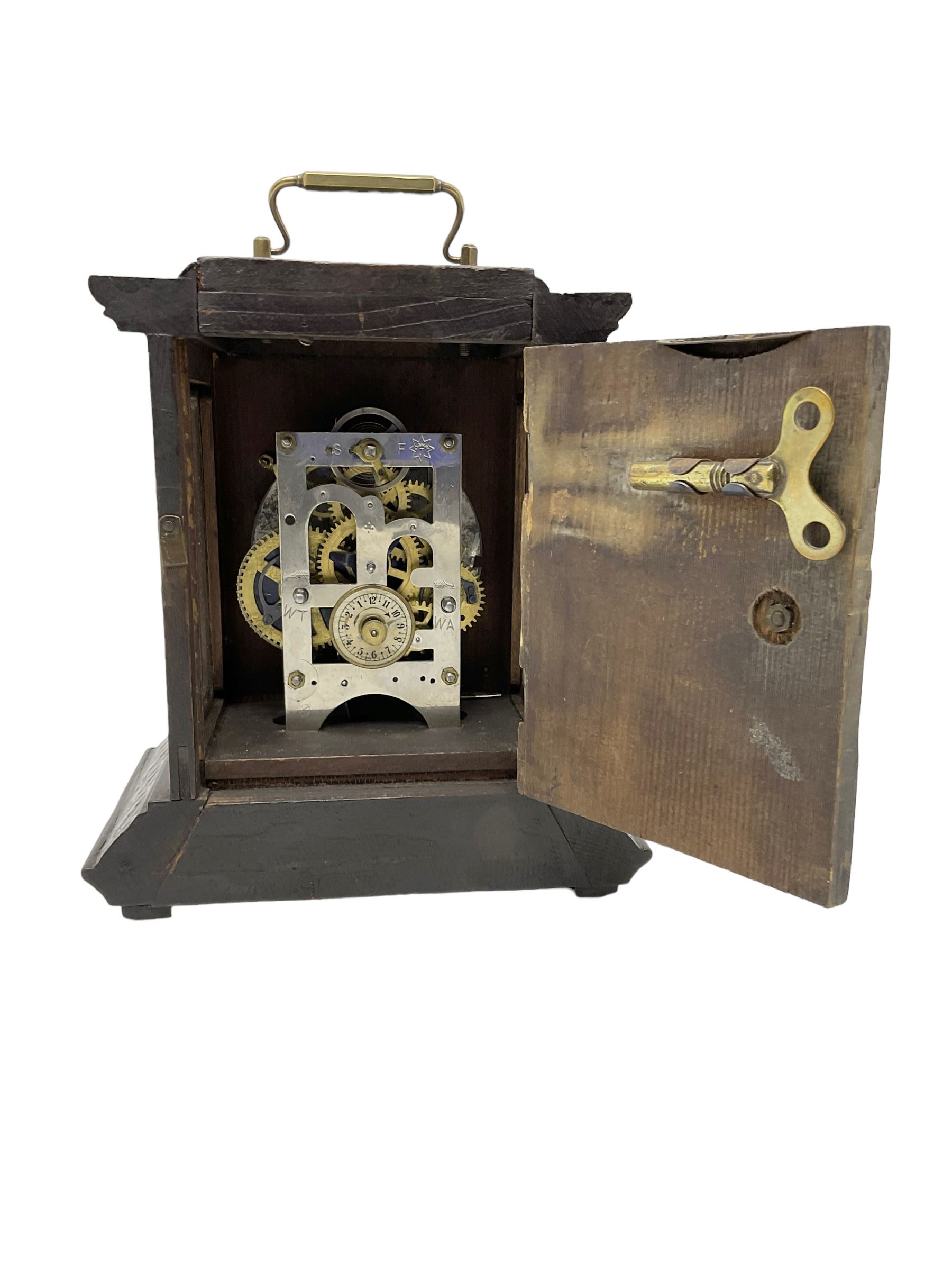 German - late 19th century  Black Forest Junghans alarm clock, profusely carved mouldings with glass side panels and carrying handle, two part dial with a gilt centre, Arabic numerals, minute track and steel spade hands, 30hr  balance wheel movement with alarm sounding on a bell, wound and set from the rear, with Key.