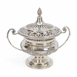 Early 20th century silver twin handled lidded bowl, of circular form with C scroll handles, the body embossed with floral swags, the pierced lid with pineapple finial, hallmarked Horace Woodward & Co Ltd, London 1911, H16cm