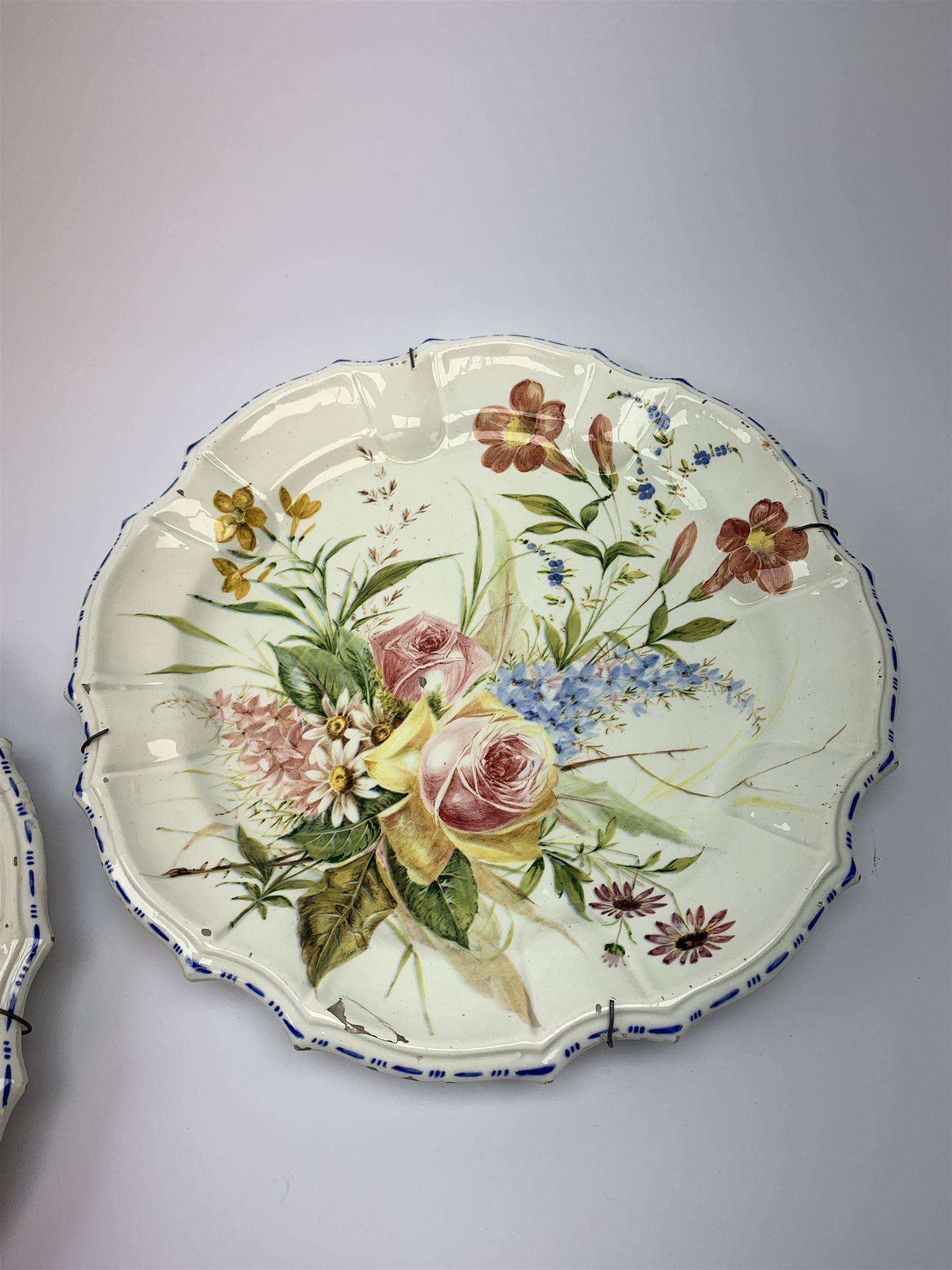 A pair of Italian faience pottery plates, by Giovanni Battista Viero, each of circular form with piecrust rim, with painted floral decoration, each with painted mark beneath, (a/f), D37.5cm