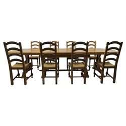 Oak extending dining table with elegant scrolled shaped double pedestal base and scrolled feet; together with a set of eight ladder back chairs with rush seats ((9) table closed 228x95x79cm chairs 106x38x44cm 