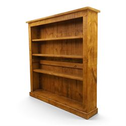 Indigo Furniture - large rustic oak open bookcase, with four adjustable shelves, above a plinth base 