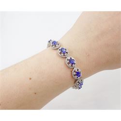 18ct white gold tanzanite and diamond bracelet, twelve oval link clusters set with oval cut tanzanite's and round brilliant cut diamonds, stamped 750, total tanzanite weight approx 7.15 carat, total diamond weight approx 4.00 carat