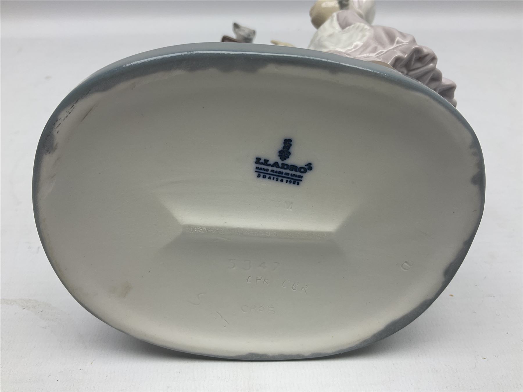 Lladro figure, Bedtime, modelled as a young girl reaching for her pet cat upon grandfather clock, sculpted by Vincente Martinez, with original box, no 5347, year issued 1986, year retired 1998, H28cm