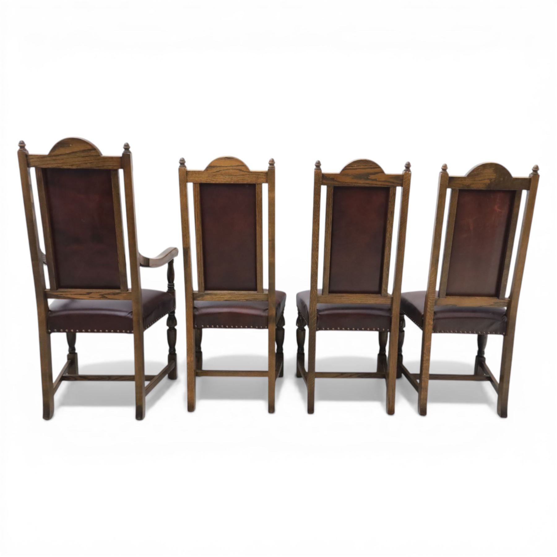 Carolean revival oak dining table and eight chairs (7+1), refectory table with rectangular boarded top and cleated ends, raised on shaped trestle end supports with central stretcher, accompanied by eight high-back chairs including a carver, leather upholstered panels and seats with studwork, on turned legs with stretchers.