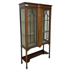 Edwardian inlaid mahogany display cabinet, enclosed by two astragal glazed doors, bowed centre inlaid with ribbon and trailing bellflowers, on square tapering supports with spade feet united by undertier 