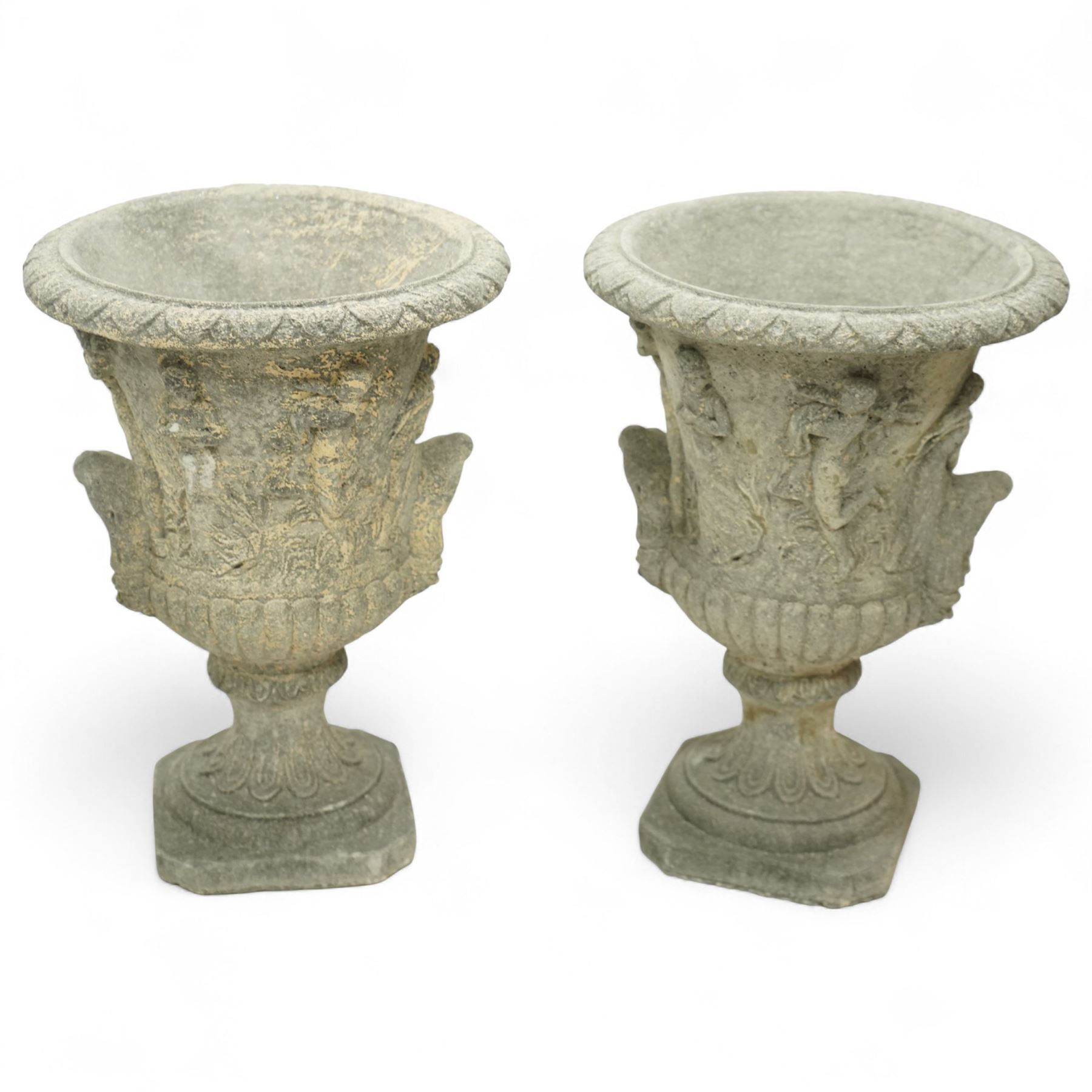 Late 20th century set of four composition stone campana urns, each with everted rim over acanthus and mask relief decoration, tapering to a fluted socle on square plinth base