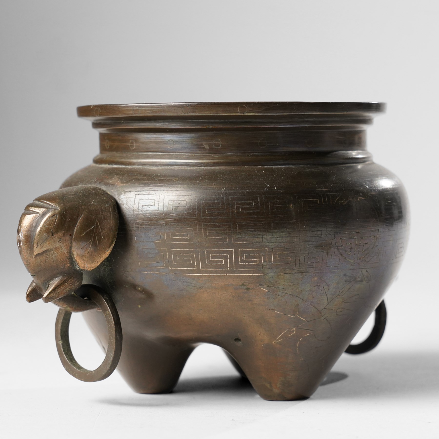 Chinese bronze tripod censer, of squat globular form, the body decorated with a band of Greek key motifs, the twin handles formed as two elephants heads, with incised shi shou two-character mark to base, H10cm