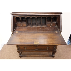  Early 20th century oak bureau bookcase, two glazed doors, three shelves, above fall front enclosing fitted interior, three graduating drawers with geometric pattern, turned support joined by stretchers, W98cm, H221cm, D48cm  