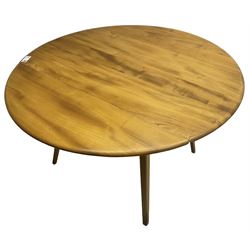 Ercol - mid-20th century golden elm drop-leaf dining table, circular top over splayed supports