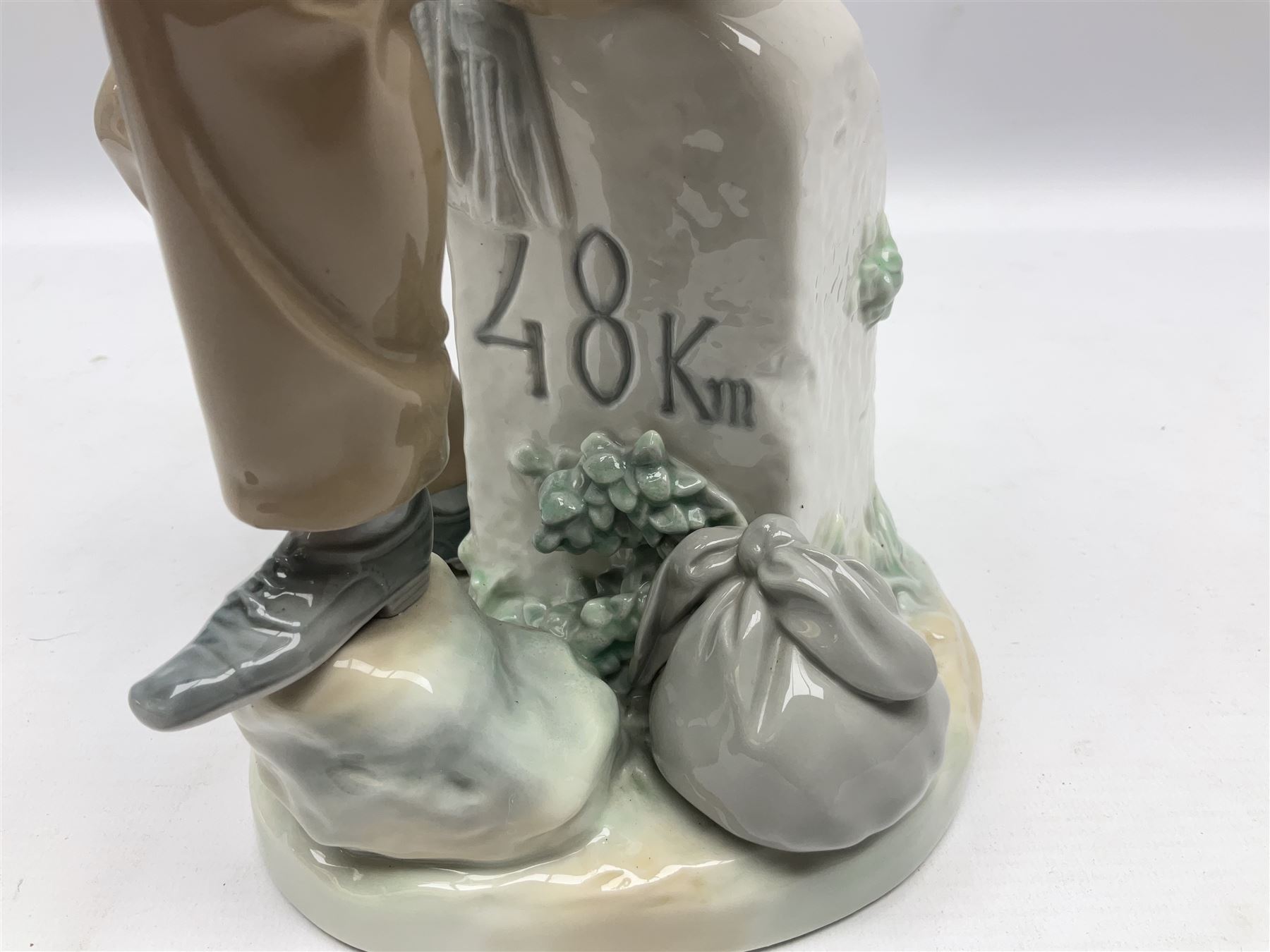 Lladro figure, Violinist, modelled as a man seated upon a  mile stone holding a violin, sculpted by Salvador Furió, no 4887,  year issued 1984, year retired 1981, H35cm