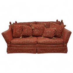 Large Knole design hardwood-framed three-seat drop-arm sofa, upholstered in crimson fabric decorated with trailing acanthus leaves and shields, together with scatter cushions 