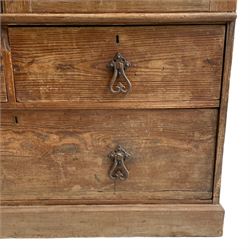 19th century pitch pine squat linen press, two panelled doors enclosing slide, fitted with two short and one long drawer, scroll wrought metal handles, on skirted base  