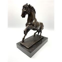 Bronze figure modelled as a prancing horse, upon a naturalistically modelled rectangular base, and black marble plinth, H34.5cm, L31cm