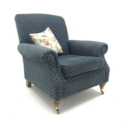 Marks and Spencers Howard style armchair upholstered in blue fabric on turned front supports with brass castors, W89cm