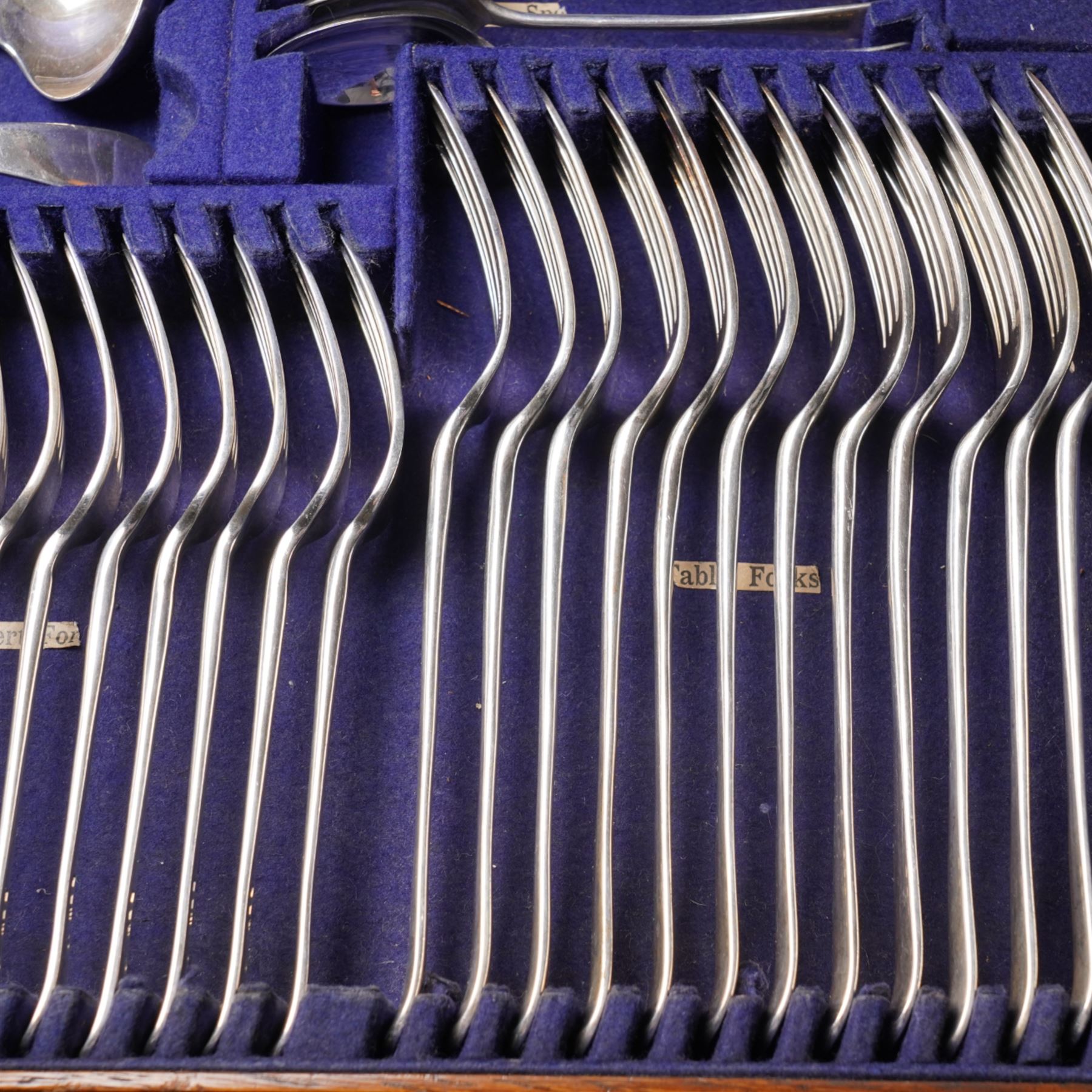 Canteen of Edwardian silver Old English pattern cutlery for twelve covers comprising twelve table forks, twelve dessert forks, twelve soup spoons, twelve dessert spoons, eleven tea spoons, pair of sauce ladles, four table spoons and a basting spoon in oak case London 1907 Maker Charles Boyton & Son