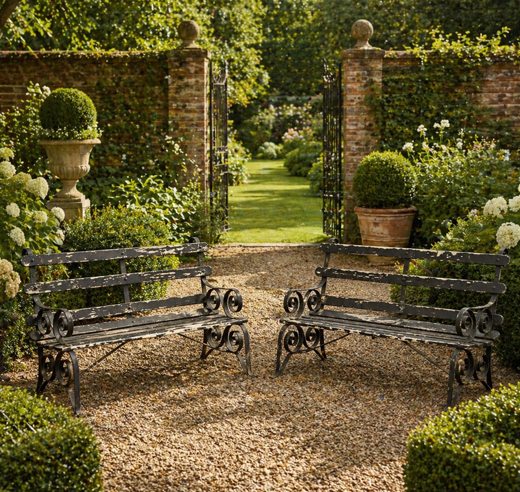 Coalbrookdale - rare pair of wrought iron and slatted wood garden benches, the twin wrought iron strapwork bench-ends formed of four scrolls over splayed feet, number 77 in the Coalbrookdale Castings Catalogue (see illustration)