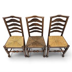Set of seven (6+1) Georgian design country elm Lancashire dining chairs, ladder backs with rush seats, turned front leg stretcher on pad feet, height of seat 44cm, complete with fitted tie on cushions