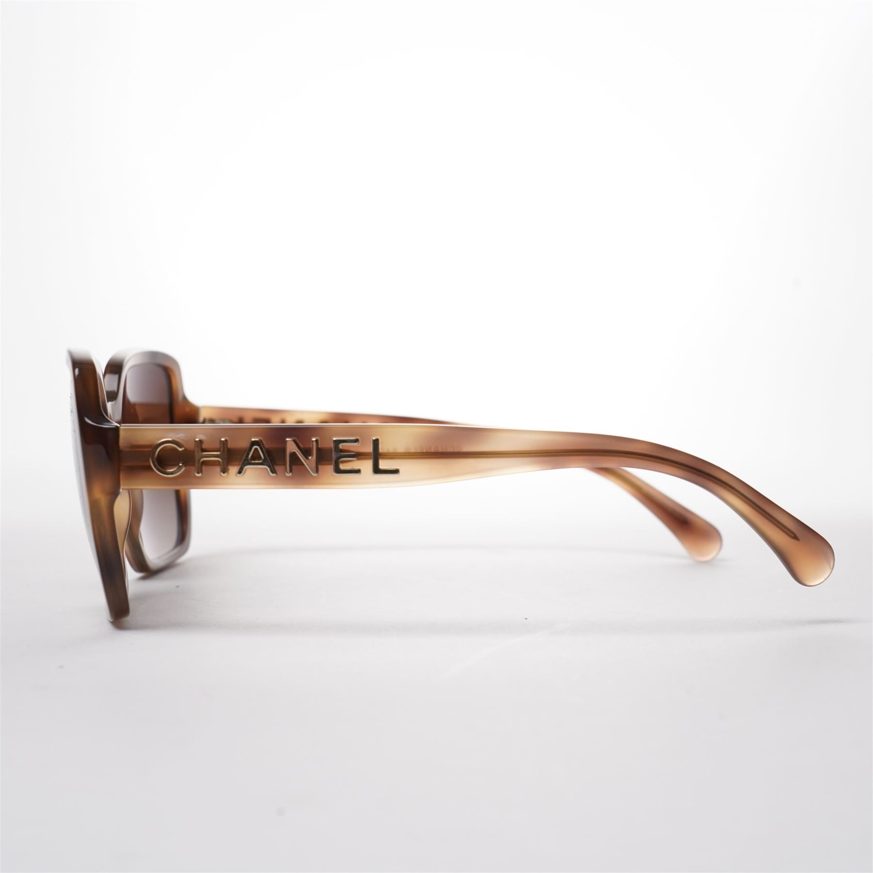 Chanel - pair of oversized sunglasses, with translucent tortoiseshell-effect brown acetate frames and gradient tinted lenses, the arms boldly set with gold-tone ‘CHANEL’ lettering, with original quilted leather case, booklet and box