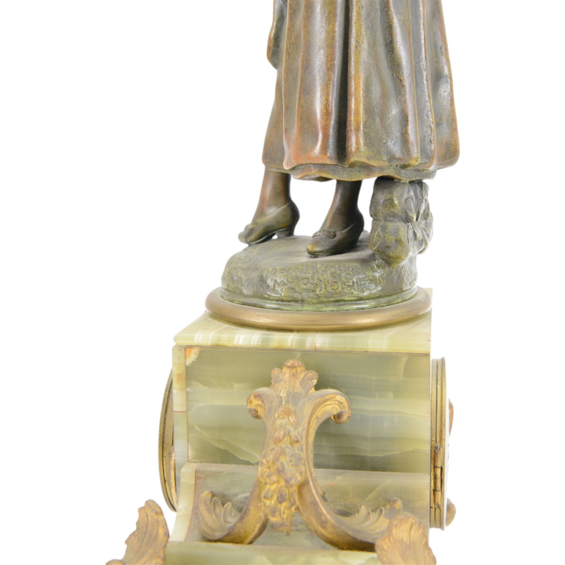 French-Edwardian green onyx clock garniture with a shaped case surmounted by a cast patinated figure of  a maiden in 18th century dress, with gilded scroll feet and conforming mounts, porcelain dial with Arabic numerals and floral decoration, twin train rack striking movement sounding the hours and half-hours on a bell, with a matching pair of five light candelabra. With pendulum.    