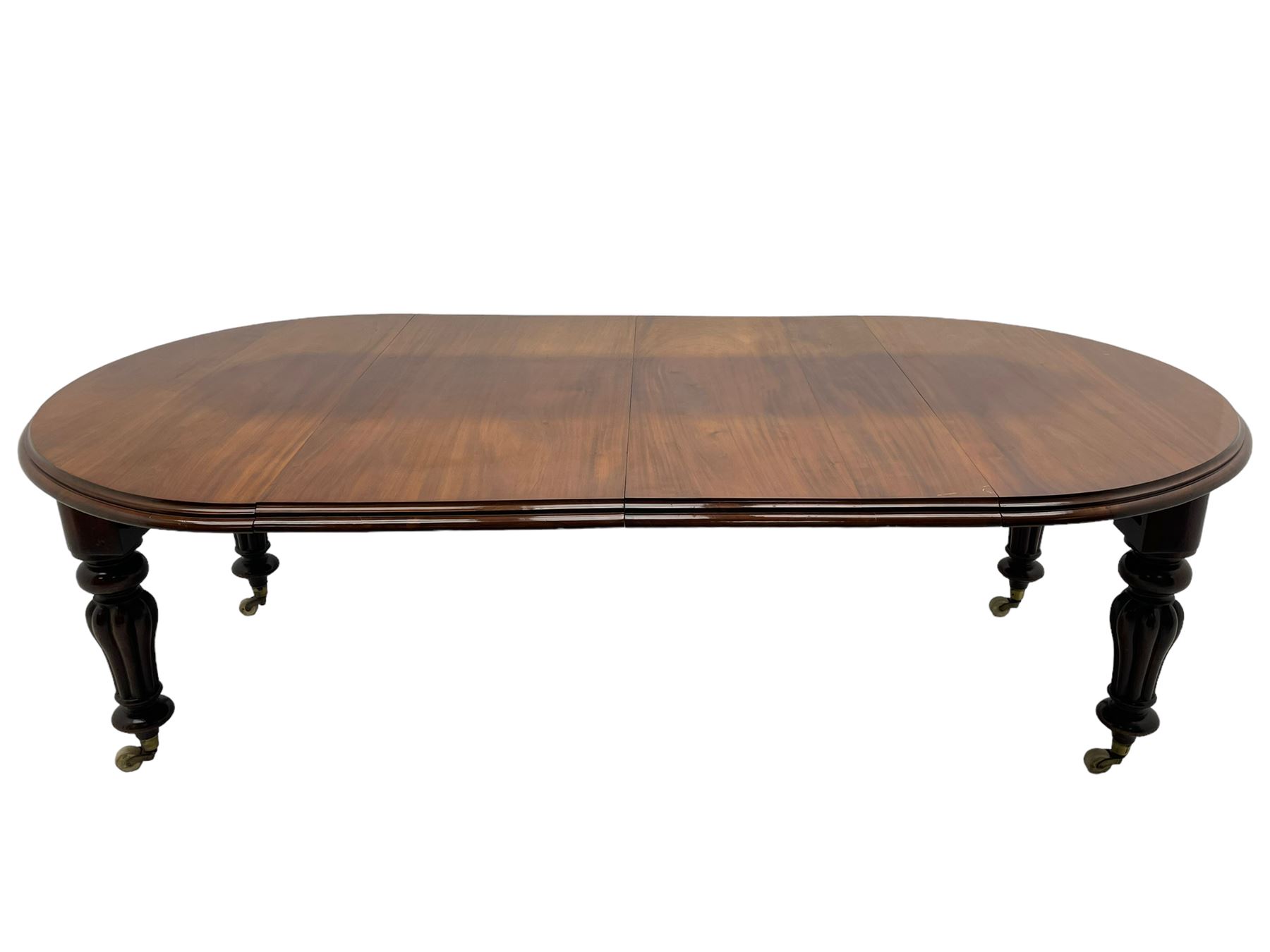 Victorian mahogany extending dining table, circular telescopic extending top with moulded edge, two additional leaves, on turned and lobe carved supports with brass and ceramic castors 