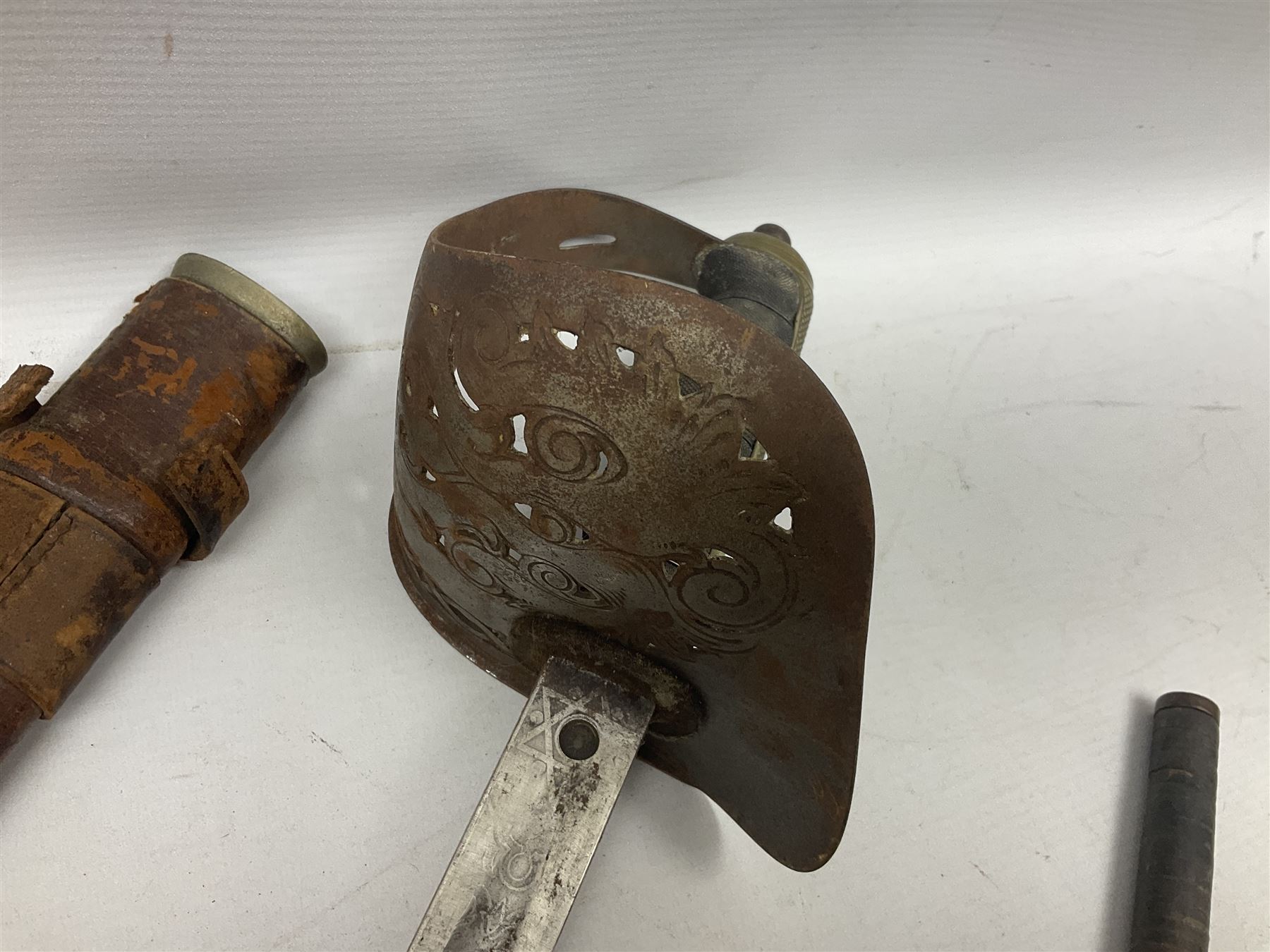 George V 1897 pattern Infantry officers sword, the 82cm single fullered blade with traces of etched detail and George V crown cipher, the ricasso marked Hawksworth Sheffield, pierced half basket hilt with George V cypher, wire-bound fish-skin grip with brass pommel and backstrap; in leather scabbard L102cm overall; together with two sectional gun cleaning rods; swagger stick made of leather strips etc