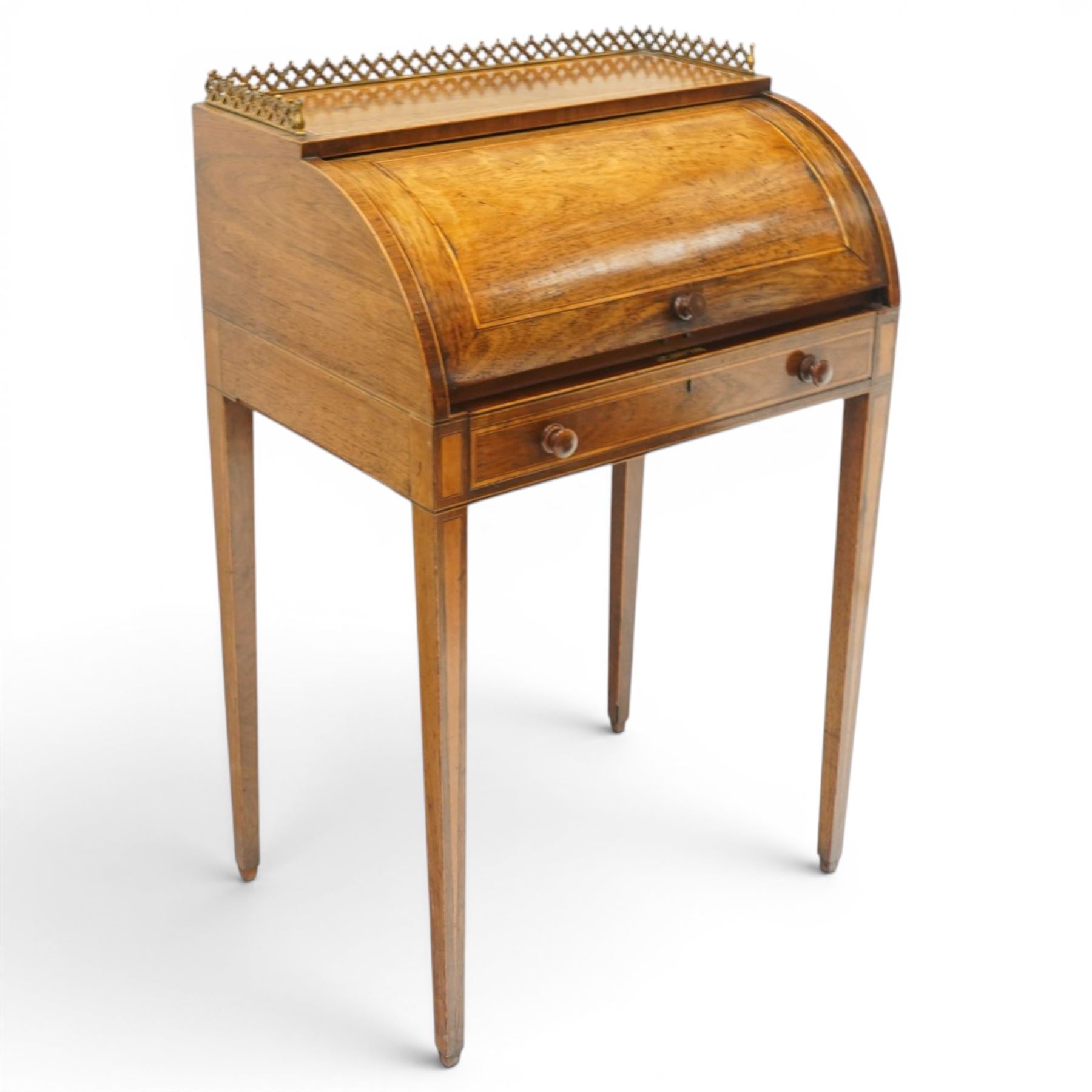 Regency period inlaid mahogany Ladies cylinder writing desk, the rectangular satinwood banded top with raised pierced brass three-quarter gallery, over a cylindrical roll-top enclosing a satinwood fitted interior with pigeonholes, correspondence drawers, ink wells and a sliding hinged writing slope, the base fitted with single frieze drawer, raised on square tapering supports
Provenance: Kirkham Hall