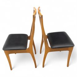 Sutcliffe of Todmorden - mid 20th century ‘S-Form’ teak dining table and chairs, the circular storable extending table with plain veneered top on tapered supports, together with matching dining chairs upholstered in black vinyl, with curved slat backs and shaped front supports, reflecting the sleek organic styling characteristic of 1960s British modern furniture design (Chairs H 93cm, W 46cm, D 46cm) (Extended 168cm)